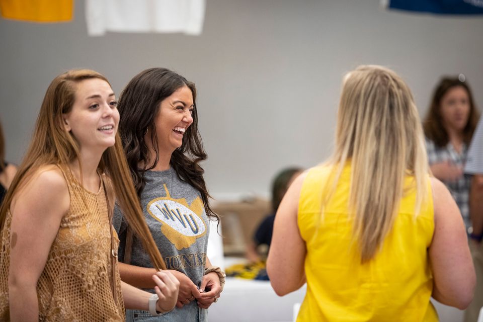 Three girls smiling and talking at a chapter event