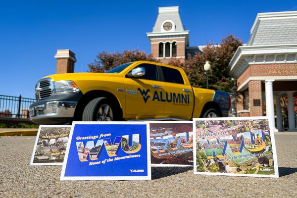 WVU Alumni Postcards sitting in front of the WVU Alumni Truck